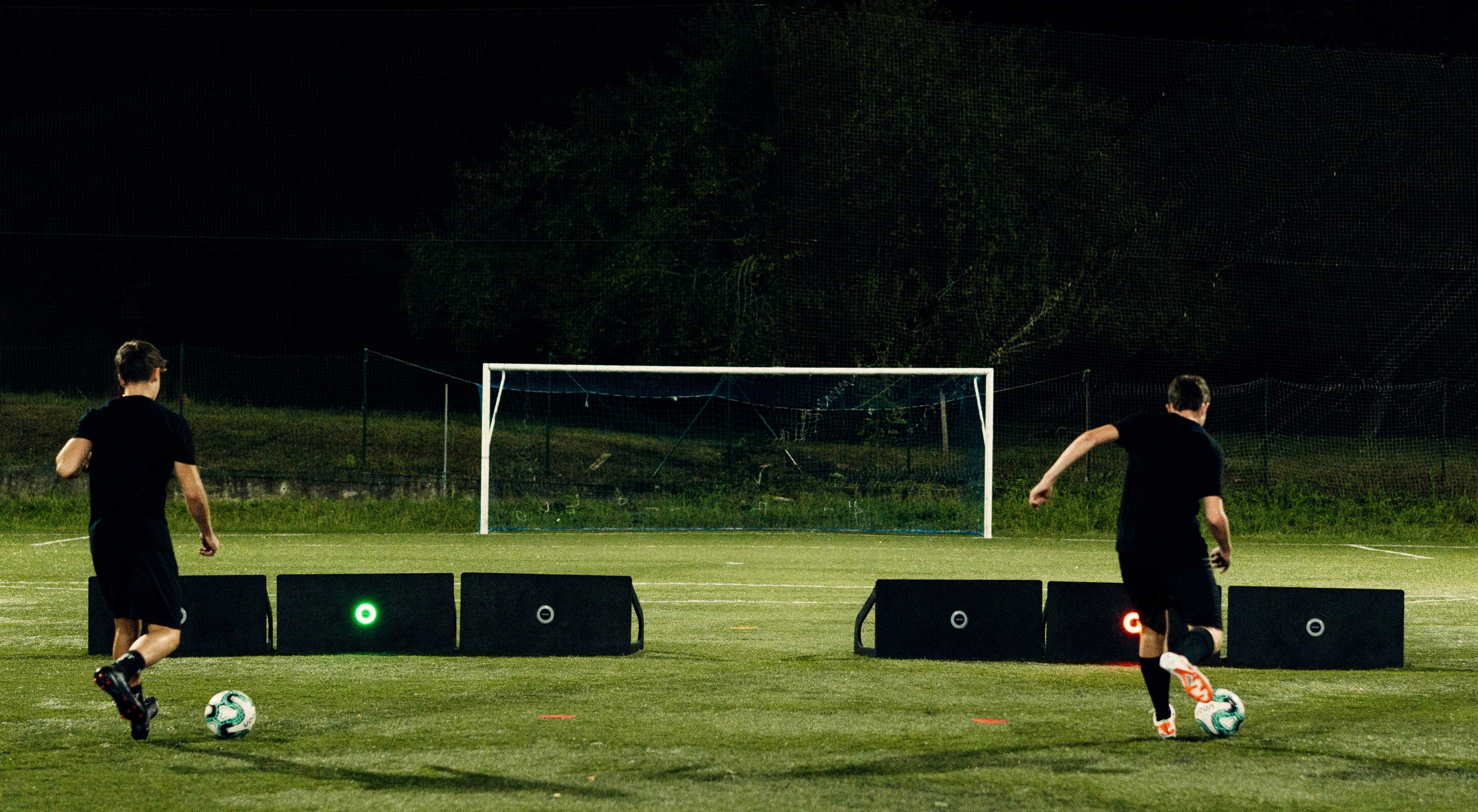 Two players using the Voon Football Pro smart rebounder to master his game and improve technical development